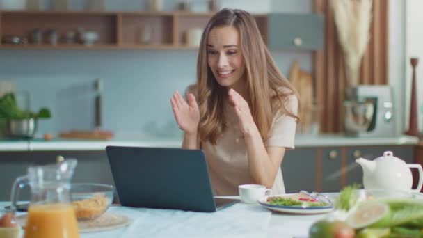 Жінка розмовляє з другом онлайн на ноутбуці. Леді жестикулює на веб-камеру вдома — стокове відео