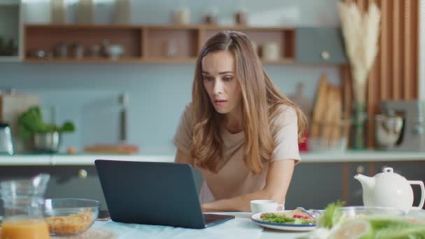 Деловая женщина использует ноутбук в домашнем офисе. Женщина, работающая на кухне — стоковое видео