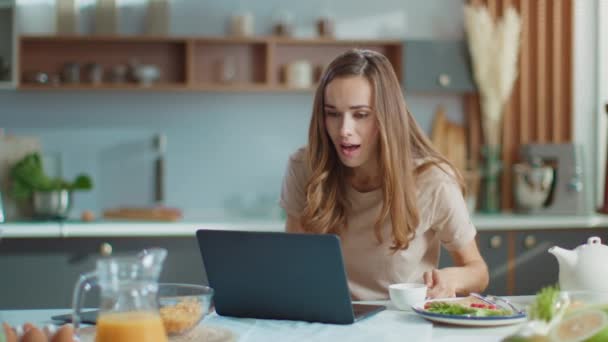 Shocked businesswoman getting good news on laptop screen at home office — Stock video