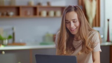 Businesswoman receiving good news on laptop at home workplace in slow motion