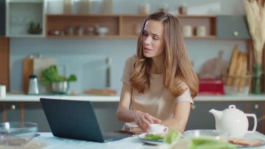 busnesswoman working on laptop at remote workplace.Woman drinking coffee at home