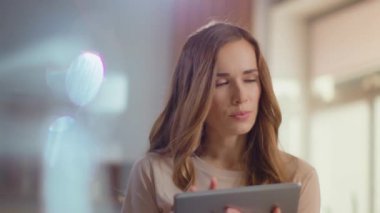 Businesswoman working on digital tablet at home office. Freelancer holding pad