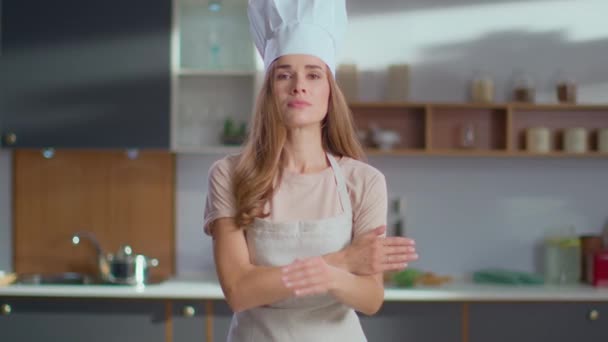 Женщина-повар скрещивает руки на рабочем месте. Женщина в шапке на кухне — стоковое видео