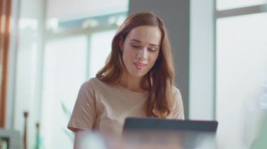 Uzak bir iş yerinde dizüstü bilgisayarda çalışan bir iş kadını. Evde dizüstü bilgisayar kullanan kadın