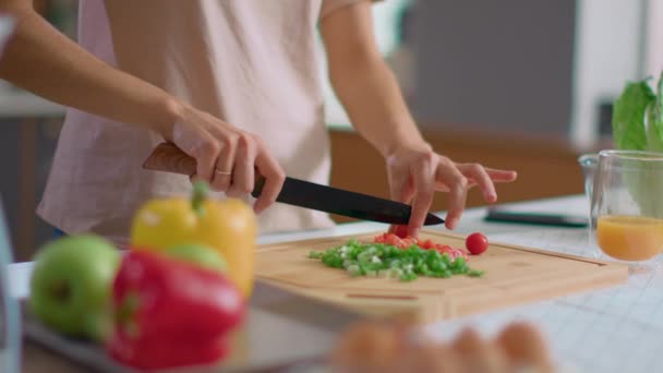 Kobieta krojąca warzywa na drewnianej desce. Uśmiechnięta pani gotowanie sałatki w kuchni — Wideo stockowe