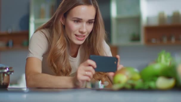 Femme prenant des photos sur smartphone de la composition des fruits à la cuisine — Video