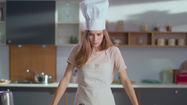 Chef cruzando cucharas en las manos en la cocina. Mujer sonriendo a la cámara — Vídeo de stock