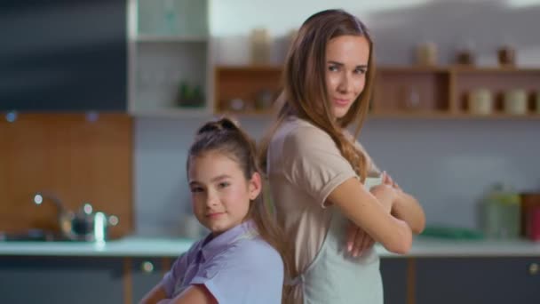 Madre e hija en delantales cruzando las manos en la cocina en cámara lenta — Vídeos de Stock