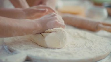Woman and girl kneading dough on kitchen in slow motion