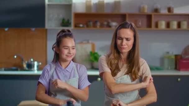 Дочь и мать танцуют на кухне. Семья веселится дома в замедленной съемке — стоковое видео