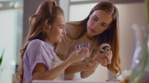 Smiling woman and girl using cookie cutters for biscuits on modern kitchen — Stock video