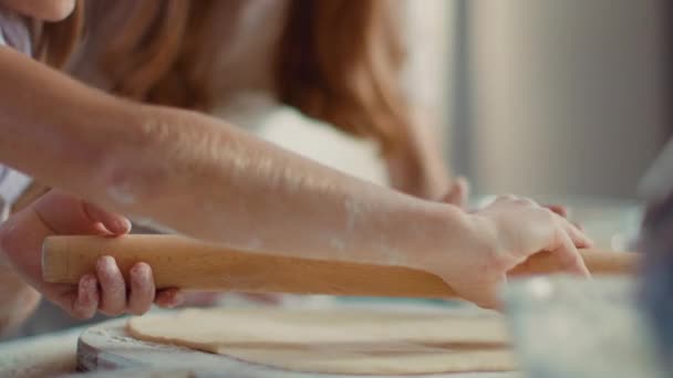 Donna insegnare ragazza a rotolare pasta sul tavolo della cucina. Ragazza mani utilizzando mattarello — Video Stock