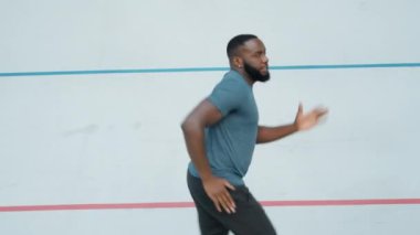 Koşu pistinde koşan bir adam. Açık havada kardiyo eğitimi sırasında koşucu nefes alıyor.