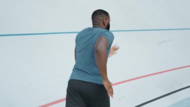 Yolda koşan bir afro adam. Erkek koşucu atletizm pistinde koşuyor