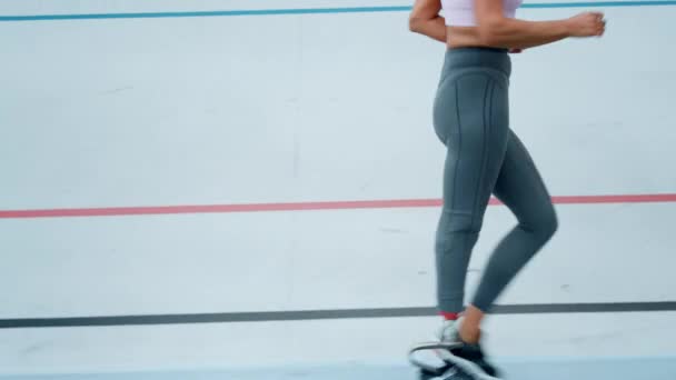 Mujer con pierna protésica corriendo en pista de carreras. Chica trotando en pista de atletismo — Vídeo de stock