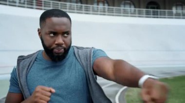 Sporcu gölgelerle dövüşüyor. Sporcunun antrenmandan önce kollarını ısıtması