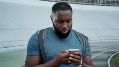 Sporcu akıllı telefondan mesaj atıyor. Cep telefonundan iyi haberler okuyan adam.