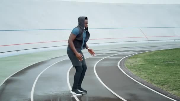 Löpare hoppar på plats på stadion.Jogger uppvärmning innan cardio träning på rätt spår — Stockvideo