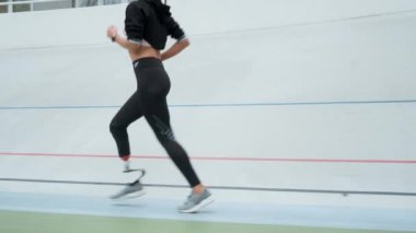 Koşu parkurunda koşan engelli kadın. Spor caddesinde koşan atlet bacakları