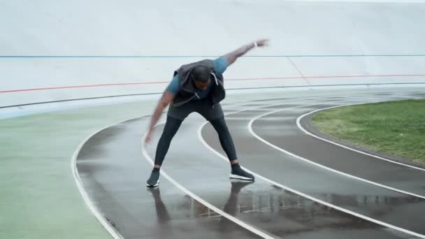 Maschio corridore preparazione per l'allenamento su pista sportiva. Ragazzo che si esercita all'aperto — Video Stock