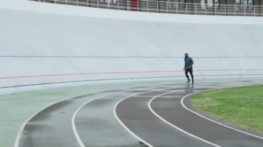 Sporcu spor pistinde koşmaya başlıyor. Spor kıyafetli adam yarış pistinde koşuyor.