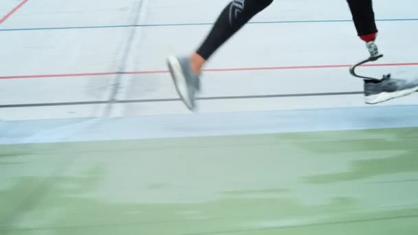 Donna disabile in scarpe da ginnastica che corre in pista. Ragazza piedi formazione allo stadio pista — Video Stock