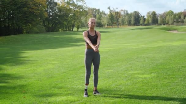 Mulher deficiente se preparando para o treino no parque. Fit menina exercitando ao ar livre — Vídeo de Stock