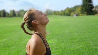 Yapay bacaklı sporcu kadın parkta yoga yapıyor. Tarlada gerinen kadın
