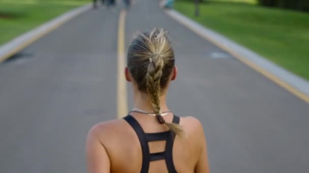Тренировка бегунов на беговой дорожке в парке. Женщина занимается на открытом воздухе — стоковое видео