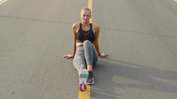 Женщина с протезной ногой отдыхает после тренировки. Девушка расслабляется после пробежки — стоковое видео