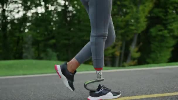 Femme coureuse avec membre artificiel faisant de l'exercice dans le parc.Fille jambes courir à l'extérieur — Video