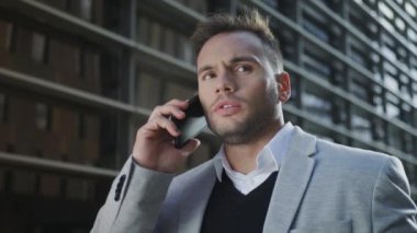 İş adamı sokakta cep telefonuyla konuşuyor. Akıllı telefonda yönetici tartışması