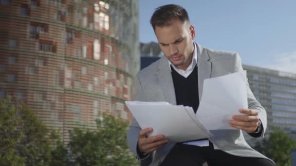Geschäftsmann schaut sich auf der Straße Papiere an. Manager feiert Erfolge auswärts — Stockvideo