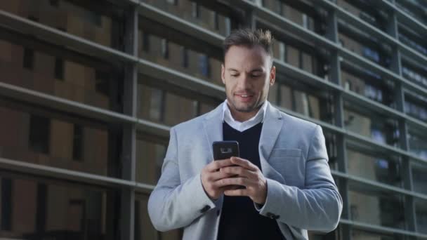 Homme d'affaires recevant de bonnes nouvelles au téléphone. Travailleur utilisant un téléphone portable dans la rue — Video