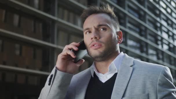 Üzletember beszél mobilon az utcán. Végrehajtó érvelés okostelefonon — Stock videók