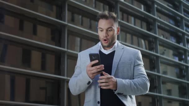 Geschäftsmann liest gute Nachrichten auf dem Smartphone. Mann arbeitet am Handy — Stockvideo