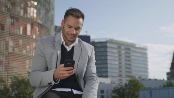 Hombre de negocios escribiendo en el teléfono inteligente en la calle. hombre de negocios trabajando en el teléfono — Vídeo de stock