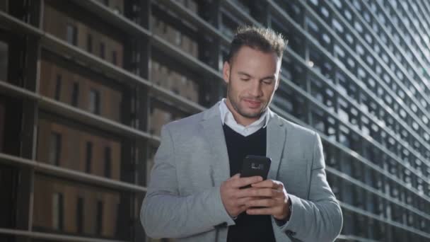 Businessman using smartphone on street. Worker browsing internet on phone — Stock Video