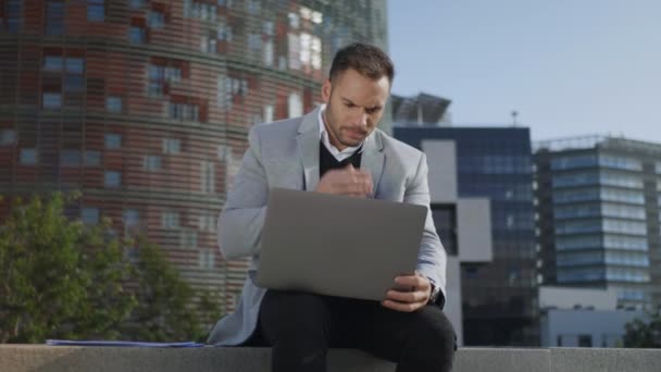 Biznesmen pracujący na laptopie w mieście. Pracownik przeglądający Internet na komputerze — Wideo stockowe