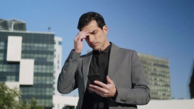 Sokaktaki akıllı telefona bakan bir iş adamı. Girişimci ortak bekliyor