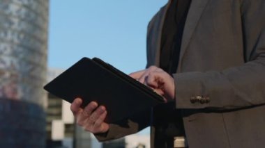 İşadamı elleri sokakta dijital tablet üzerinde çalışıyor. Çalışan dokunmatik ped kullanıyor