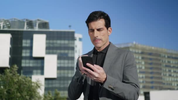 Empresario leyendo buenas noticias por teléfono en la calle. Profesional disfrutando del éxito — Vídeo de stock