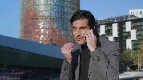 Un uomo d'affari che parla al telefono in strada. Operaio che celebra la vittoria all'aperto — Video Stock