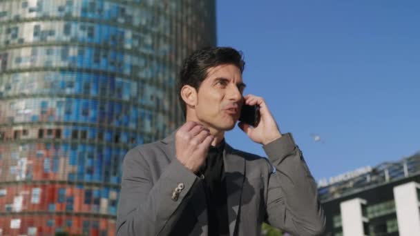 Obchodník mluví o mobilu na ulici. Executive slaví úspěch — Stock video