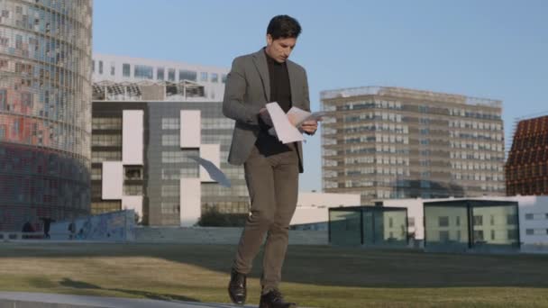 Geschäftsmann liest Dokumente auf der Straße. Professionelles Gehen im Freien — Stockvideo