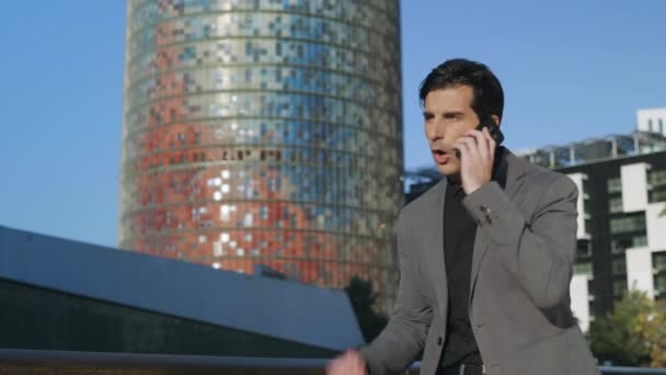 İş adamı sokakta telefonda tartışıyor. Erkek çalışan akıllı telefondan konuşuyor. — Stok video