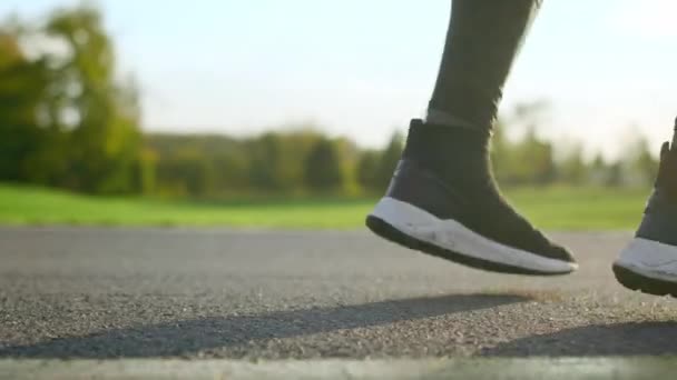 사람 발은 도로 위에서 춤을 춘다. 공원에서 뛰고 있는 활기찬 스포츠맨 다리. — 비디오