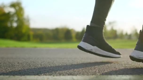 Pies de hombre bailando en la carretera. Activo deportista piernas saltando en parque. — Vídeo de stock