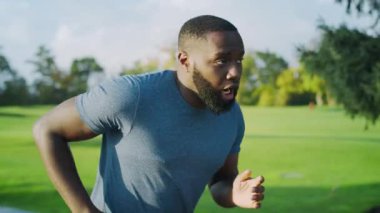 Yorgun bir sporcu parkta hızlı koşuyor. Maraton sırasında nefes alan bir adam.