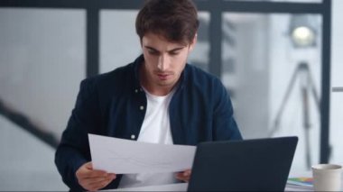 Focused businessman reading document carefully. Concentrated man looking papers